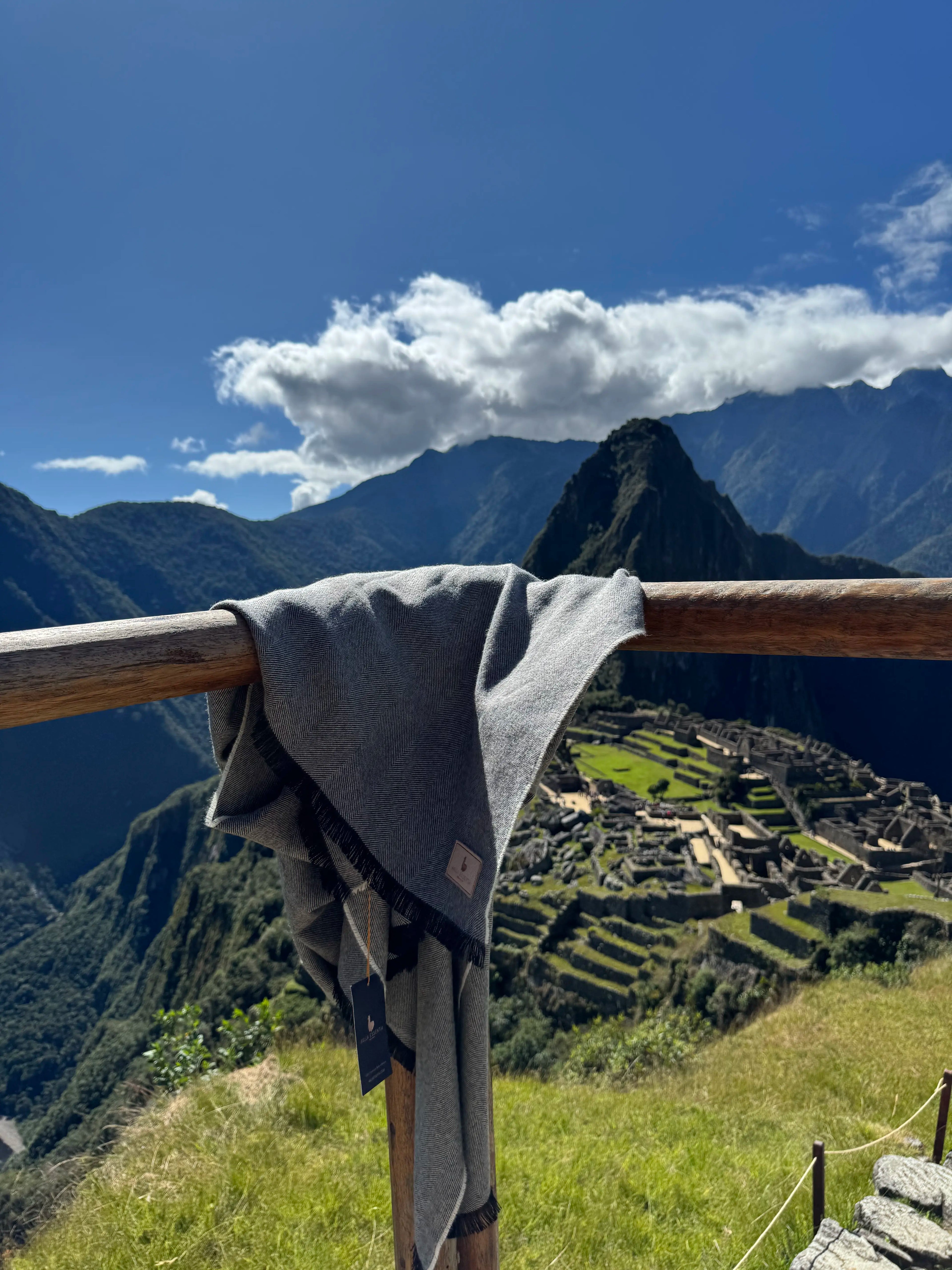 Manta de baby alpaca gris de Aklla Essentia sobre Machu Picchu, hecha en Perú con fibra natural.